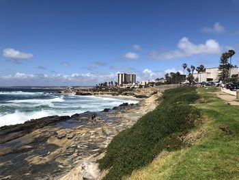 Scenic view of sea by buildings against sky