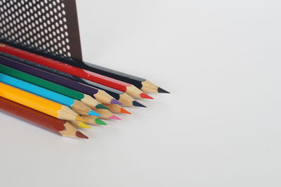 High angle view of multi colored pencils on white background