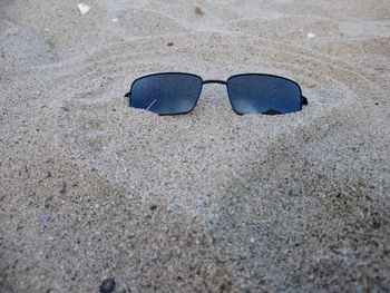 High angle view of sunglasses on sand