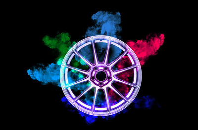 Low angle view of illuminated ferris wheel against black background