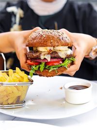 Midsection of woman holding burger