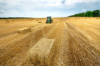 Tractor on agricultural field against sky