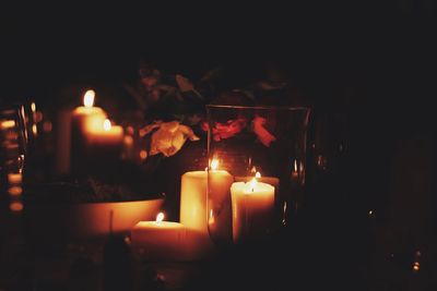 Close-up of lit tea light candles in darkroom