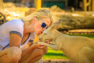 Full length of woman kissing by kangaroo