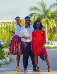 Full length portrait of smiling young women standing outdoors