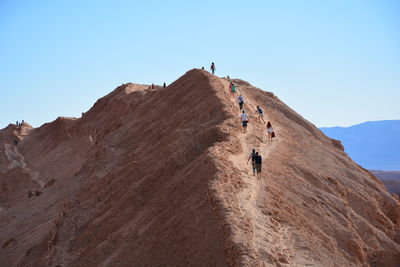Low angle view of people hiking on mountain