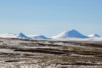 Scenic view of snowcapped mountains against clear sky