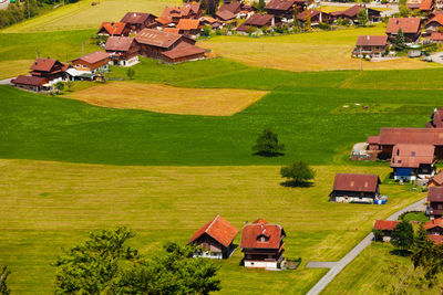 High angle view of houses on field against buildings