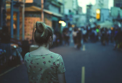 Rear view of woman standing on street