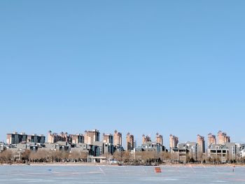 View of cityscape against clear blue sky