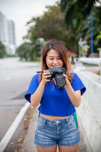 Young woman photographing with camera