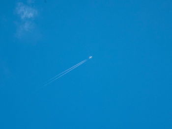 Low angle view of vapor trail against clear blue sky