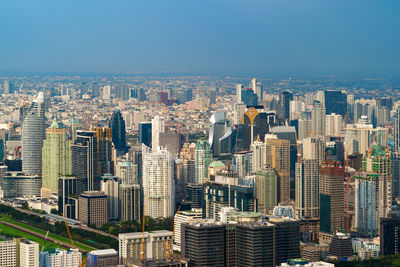 Aerial view of buildings in city against sky