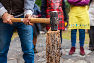 Close-up of people holding wood