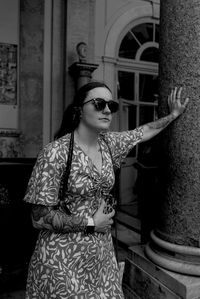 Portrait of young woman standing against wall