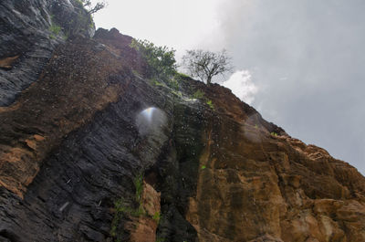 Low angle view of rock formation against sky