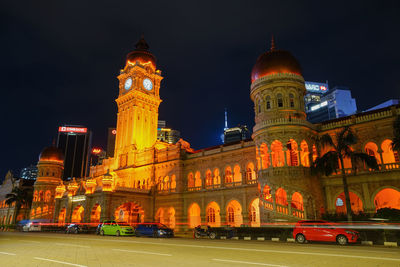 Illuminated buildings against sky at night