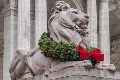 Statue against trees and christmas tree