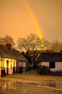 Houses against sky at sunset