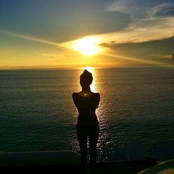 Silhouette of people in sea at sunset