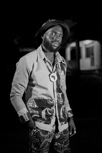 Portrait of man standing outdoors at night