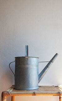 Close-up of metallic structure on table against wall