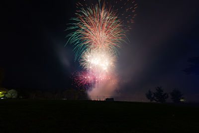 Low angle view of firework display at night