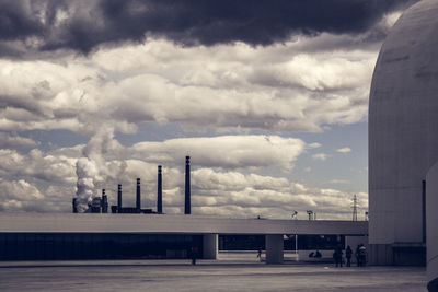 Factory against cloudy sky