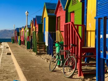 Bicycles on footpath by st james beach against blue sky