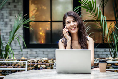 Smiling young woman using mobile phone