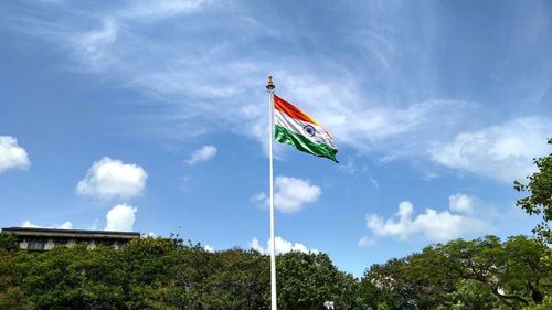 Low angle view of indian flag against blue sky