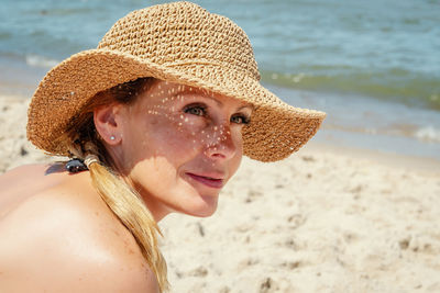 Close-up of woman in hat at beach