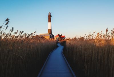 Boardwalk to fire island lighthouse against sky