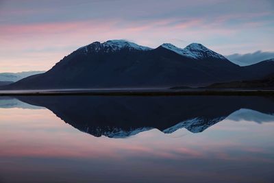 Scenic view of lake and mountains against sky during sunset