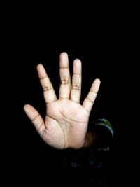 Close-up of human hand against black background