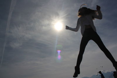 Low angle view of silhouette woman standing against sky during sunset