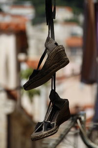 Close-up of shoes hanging on metal