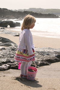 Rear view of girl standing on beach