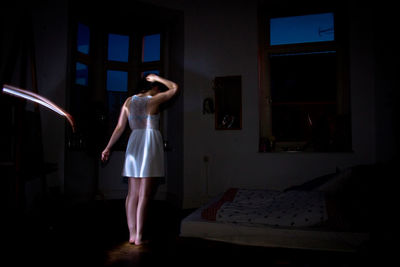 Rear view of woman standing at home