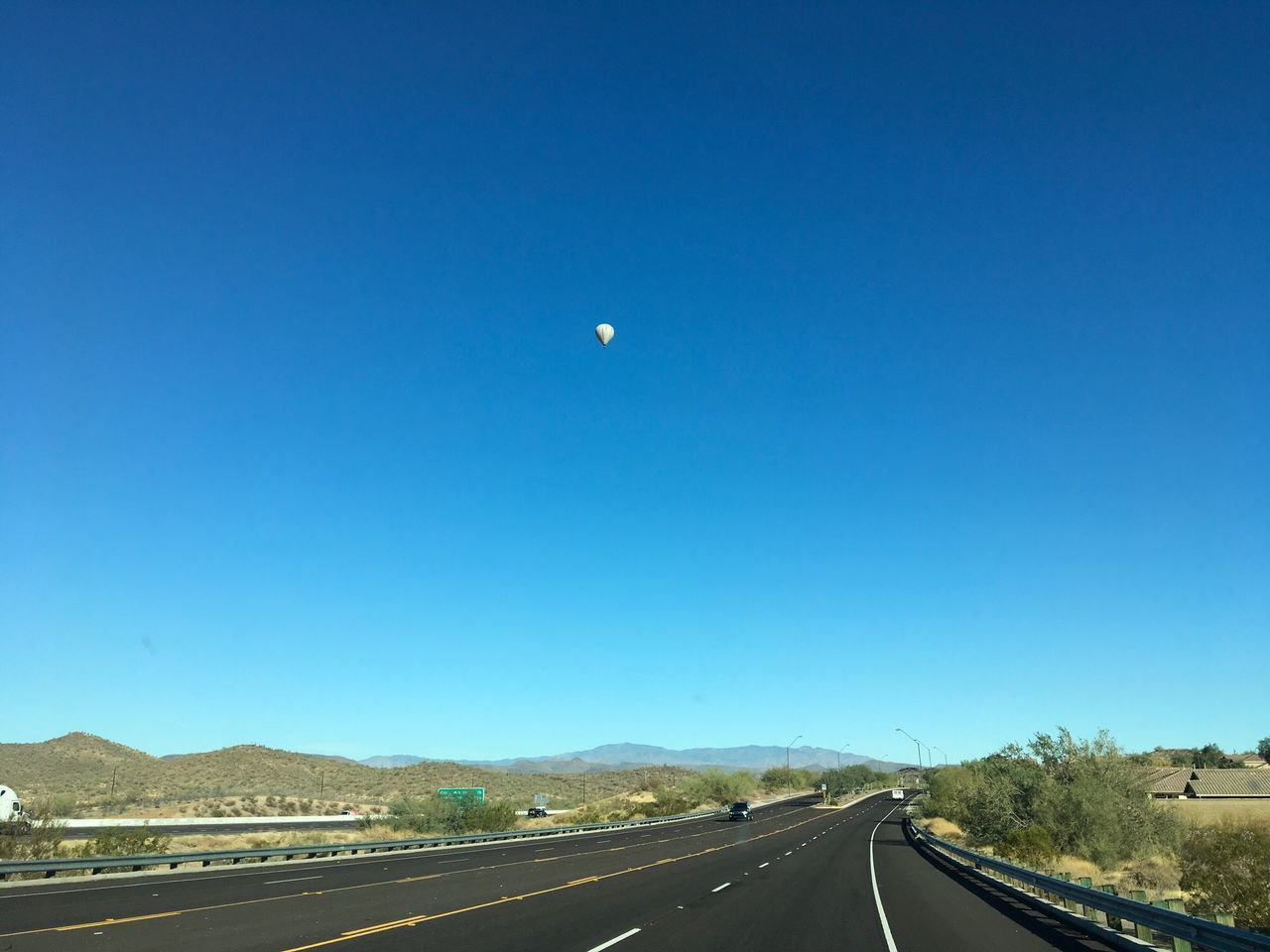 ROAD BY TREES AGAINST CLEAR BLUE SKY