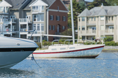 Boats moored on sea against buildings