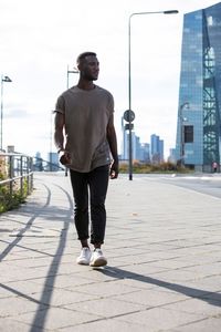 Full length of man standing on footpath in city