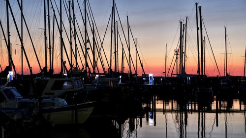 Sailboats in marina at sunset