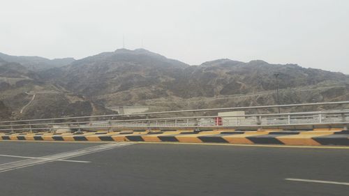 Road by mountain against sky