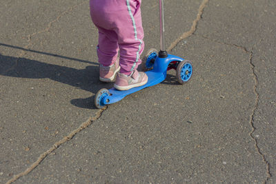 Low section of girl standing on footpath