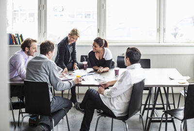 Group of business colleagues discussing at desk in office