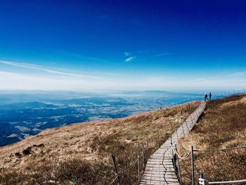 Scenic view of sea and mountains against blue sky