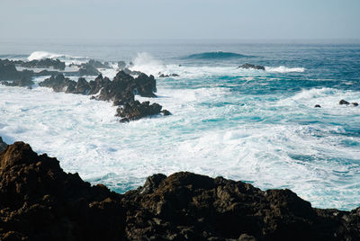 Scenic view of sea with rocks in background