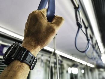 Cropped had of man holding handle in subway train