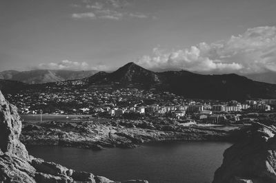 Aerial view of city by sea against sky